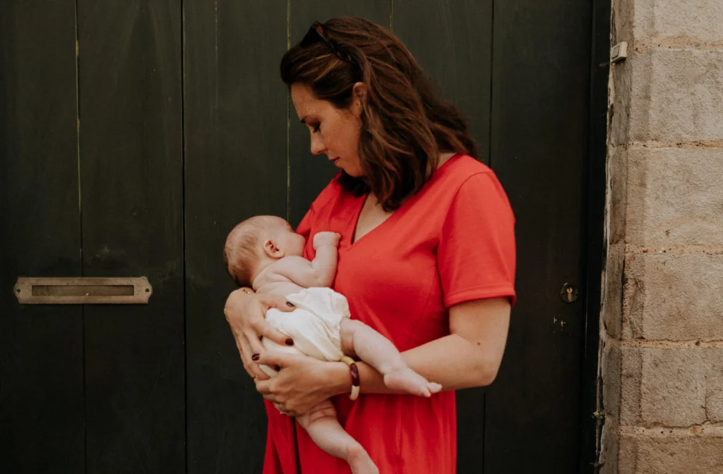 le bébé est en train d'allaiter sa maman qui porte une robe d'allaitement